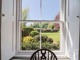 A window view of a garden with grass and bushes at Goulds Farmhouse in Milborne St Andrew