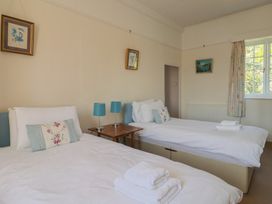 A bedroom with two beds and a table at Goulds Farmhouse in Milborne St Andrew