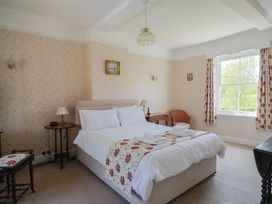 A bedroom with a bed and bedside table at Goulds Farmhouse in Milborne St Andrew