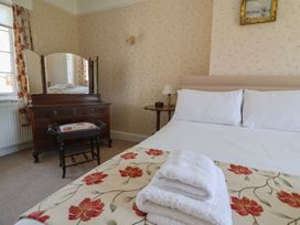 A bedroom with a bed and mirror at Goulds Farmhouse in Milborne St Andrew