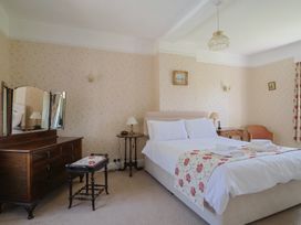 A bedroom with a bed and a dressing table at Goulds Farmhouse in Milborne St Andrew