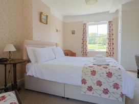 A bedroom with a bed and window at Goulds Farmhouse in Milborne St Andrew