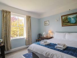 A bedroom with a bed and a lamp at Goulds Farmhouse in Milborne St Andrew