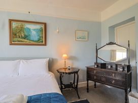A bedroom with a bed and dresser at Goulds Farmhouse in Milborne St Andrew