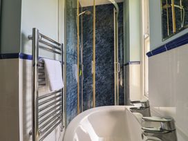 A bathroom with a shower and bathtub at Goulds Farmhouse Milborne St Andrew