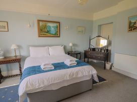 A bedroom with a bed and a mirror at Goulds Farmhouse in Milborne St Andrew