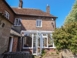 A conservatory attached to a brick house at Goulds Farmhouse in Milborne St Andrew