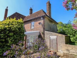 A house with flowers and a shed at Goulds Farmhouse in Milborne St Andrew