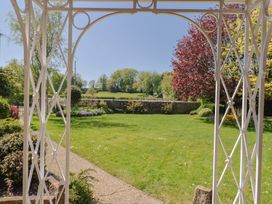 A garden with a view through a gazebo at Goulds Farmhouse in Milborne St Andrew