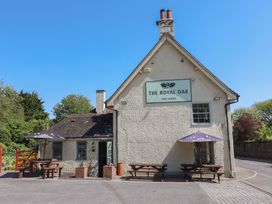 An outdoor seating area of a pub with tables and umbrellas at The Royal Oak in Milborne St Andrew