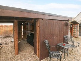An outdoor area with a table and chairs beside a wooden shed at Tooth Suite Yarm