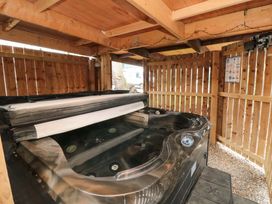 A hot tub in a wooden shelter area at Tooth Suite Yarm