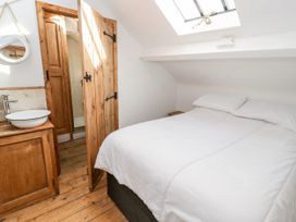 A bedroom with a bed and sink in the corner at Studio Bach in Beaumaris