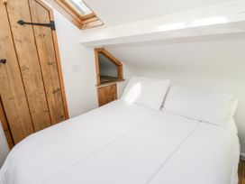 A bedroom with a bed and wooden door at Studio Bach in Beaumaris