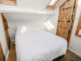 A bedroom with a bed and wooden door at Studio Bach in Beaumaris