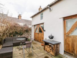 A garden with seating and a barbecue grill at Studio Bach in Beaumaris