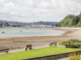 A view of boats on water by a rocky shore at Studio Bach in Beaumaris