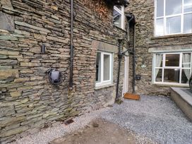 An outdoor area with stone walls and a door at Flat 5 Caxton House in Windermere