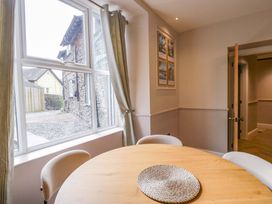 A dining room with a round table and chairs at Flat 5 Caxton House in Windermere