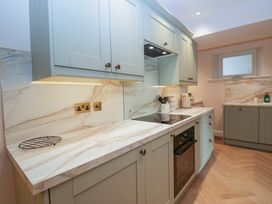 A kitchen with cabinets, countertop, and appliances at Flat 5 Caxton House in Windermere