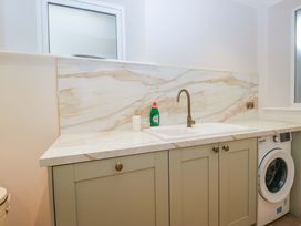 A laundry room with a sink and washing machine at Flat 5 Caxton House in Windermere