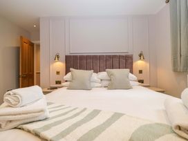 A bedroom with a bed and bedside lamps at Flat 5 Caxton House in Windermere