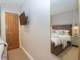 A bedroom with a bed and a television at Flat 5 Caxton House Windermere