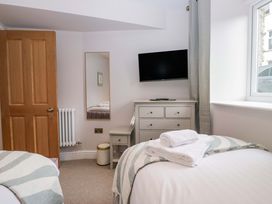 A bedroom with a bed and dresser at Flat 5 Caxton House Windermere