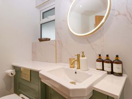 A bathroom with a sink and mirror at Flat 5 Caxton House in Windermere