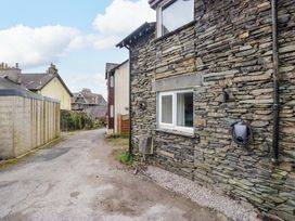 An outdoor area with a stone wall and a gravel pathway at Flat 5 Caxton House Windermere