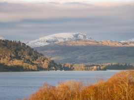 A landscape view of a lake surrounded by mountains and trees at Flat 5 Caxton House Windermere