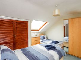 A bedroom with two beds and a dresser at Bodlasan Groes Cottage in Holyhead