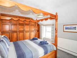 A bedroom with a four-poster bed and wardrobe at Bodlasan Groes Cottage in Holyhead
