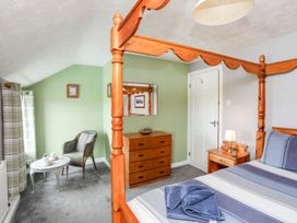 A bedroom with a four-poster bed and dresser at Bodlasan Groes Cottage in Holyhead