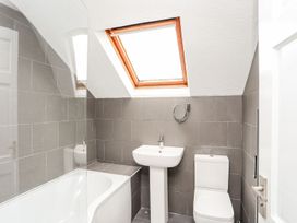 A bathroom with a bathtub, sink, and toilet at Bodlasan Groes Cottage Holyhead