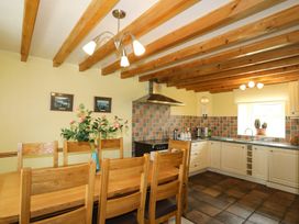 A kitchen with a dining table and chairs at Bodlasan Groes House in Holyhead