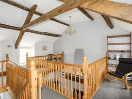 A landing area with wooden railing and shelves at Bodlasan Groes House Holyhead