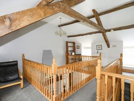 A landing with wooden beams and a bookshelf at Bodlasan Groes House in Holyhead