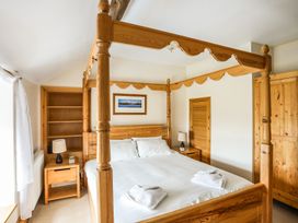 A bedroom with a canopy bed and nightstand at Bodlasan Groes House in Holyhead
