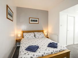 A bedroom with a bed and bedside table at Bodlasan Groes House in Holyhead