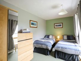 A bedroom with two beds and a lamp at Bodlasan Groes House in Holyhead