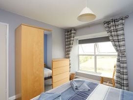 A bedroom with a wardrobe and a window at Bodlasan Groes House in Holyhead