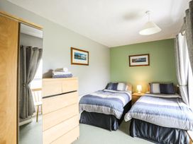 A bedroom with two beds and a dressing table at Bodlasan Groes House in Holyhead