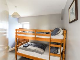 A bedroom with a bunk bed and a window at Bodlasan Groes House in Holyhead