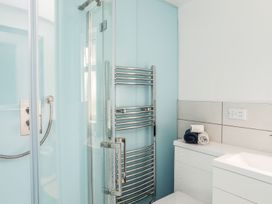 A bathroom with a shower and towel rack at Bodlasan Groes House, Holyhead
