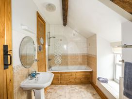A bathroom with a bathtub, sink, and shower at Bodlasan Groes House in Holyhead