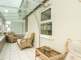A conservatory with seating area and table at Bodlasan Groes House in Holyhead