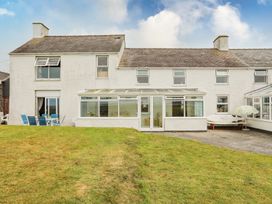 A house with a conservatory and lawn at Bodlasan Groes House in Holyhead