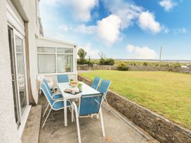 An outdoor patio with a table and chairs at Bodlasan Groes House in Holyhead