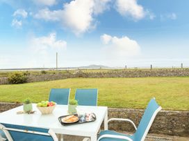 A table and chairs with apples and pastries in an outdoor space at Bodlasan Groes House Holyhead